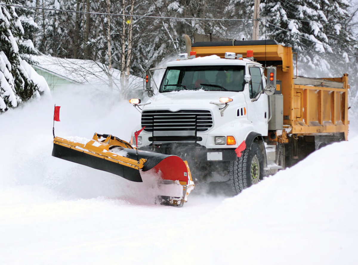 white snowplow truck plowing snow with plow PU edges